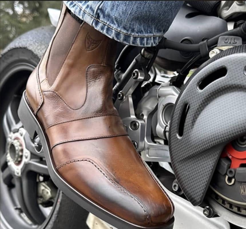 The Carrillo boot in chocolate calfskin on the foot peg of a motorcycle