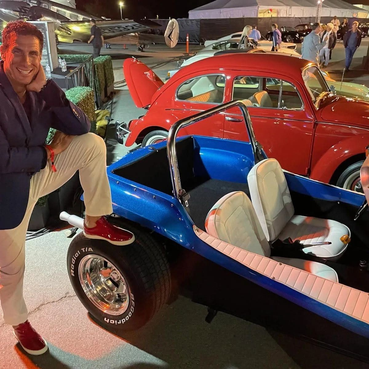 A vintage dune buggy beside a red Beetle